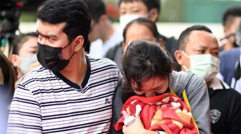 一名心碎的妈妈拿着孩子生前的奶瓶和毯子泣不成声。