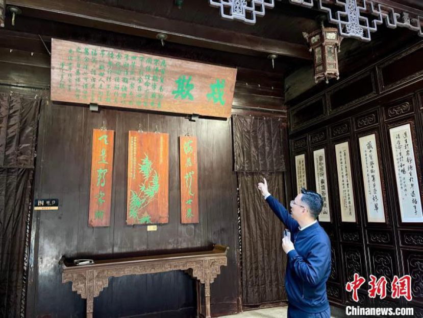 陈蕴涵向记者介绍胡庆余堂&ldquo;戒欺&rdquo;牌匾。