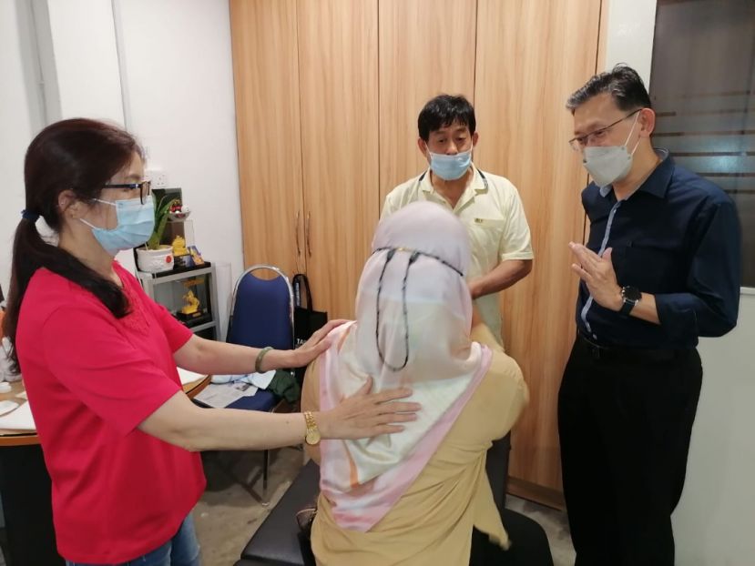 来自台湾林淑惠医师（左）为土著女士作健康检查，由人联党峇都林当支部薛华东（右）做翻译；右二为台湾著名中医许国模。