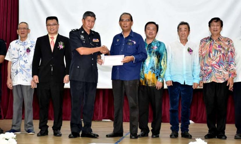 砂首长政治秘书阿都沙末干尼（右四）移交感谢状予预防犯罪案讲座会主讲人，古晋警区刑事罪案调查组罗国华副警长（左三）。