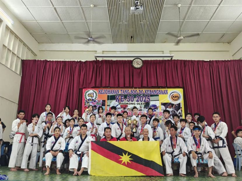 砂拉越三马拉汉唐手道协会教练与健儿团队在【2025年第30届全国唐手道锦标赛】表现卓越，赢得辉煌战绩，全体团员欣喜在西马霹雳州安顺的圣安东尼国中大礼堂赛场欢展砂拉越旗共享喜悦。