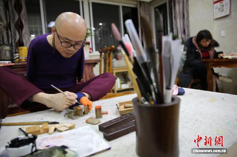 无臂书画家归晓峰在工作中。