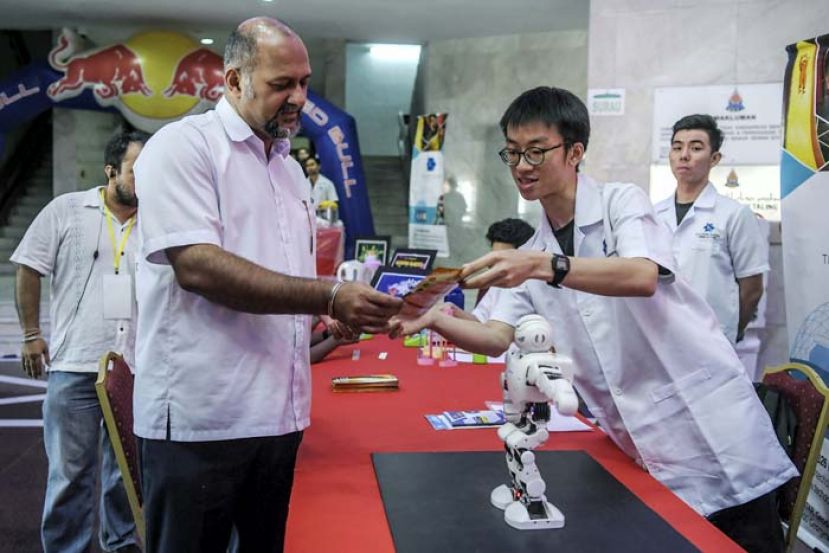 图：哥宾星在初创嘉年华会上参观机器人示范。