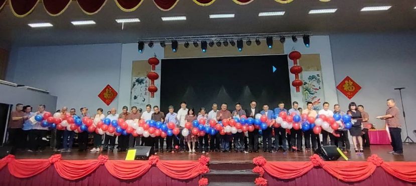 捐献搬迁和重建基金的热心人士，在台上戳气球以示剪彩时影。
