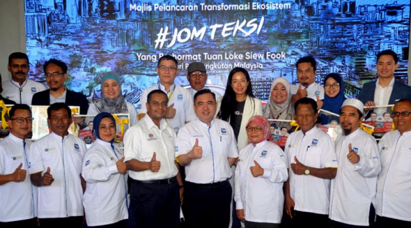 陆兆福（前排左5）为#JOMTEKSI第2阶段计划主持推介礼时，跟嘉宾及的士司机一起比赞的手势。