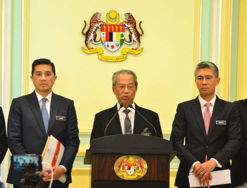 首相丹斯里慕尤丁(中)在国际贸工部长阿兹敏(左)和财政部长扎夫鲁(右)陪同下召开新闻发布会。