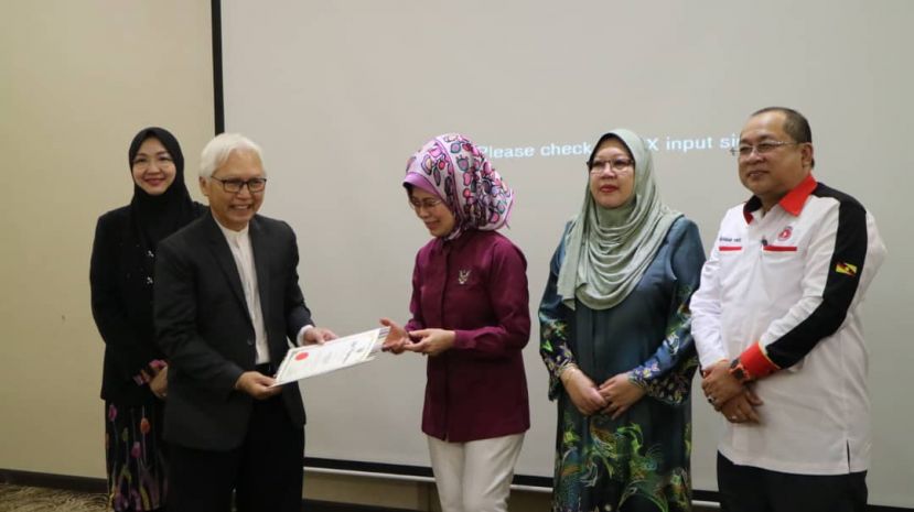 图示：砂福利、幸福社区、妇女、家庭与儿童发展部长拿督斯里法蒂玛陈赛明（中）颁发证书给予砂拉越精神保健协会会长依斯迈医生（左二）。