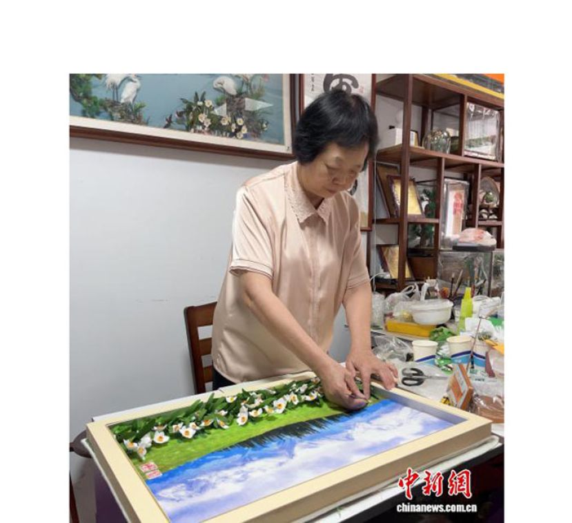 近期郭美瑜在工作室内创作一幅水仙花主题的棉花画。