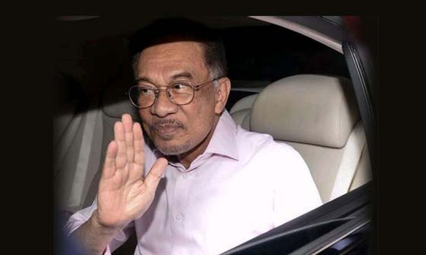 拿督斯里安华坐车进入国家王宫，向媒体挥手。