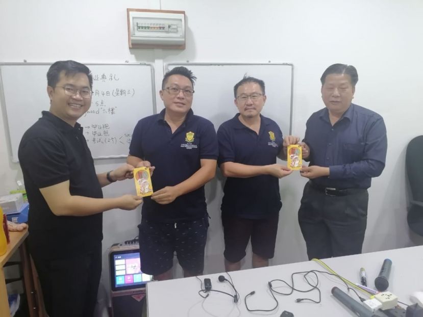 砂医总会长江宗兴（右1）、副会长江邦忠（左1）在会员庆新春会上，分别颁发新春红包予会员郑源荣（右2）及卓志盛（左2）。