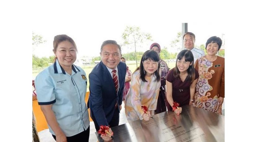 雪州行政议员黄思汉（左二起）、林慧英及张念群等在敦化小学新校舍启用礼的匾牌上签名。