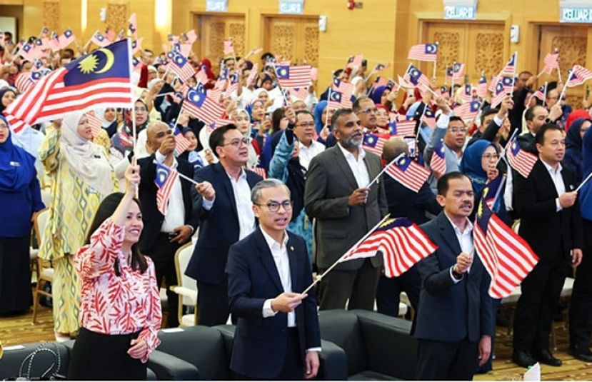 法米（右）与通讯部副部长张念群及部门官员在集会上挥国旗。