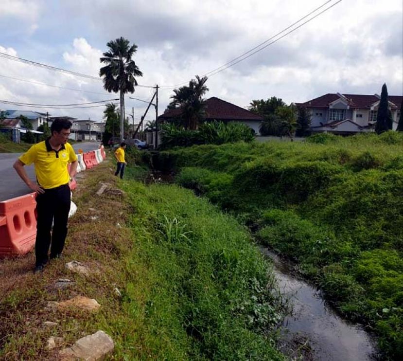 图：砂首长署政治秘书陈开（左）巡视石角路第三巷沟渠工程。