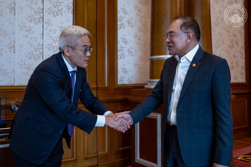 首相安华（右）与蚂蚁国际首席执行官杨鹏亲切握手。