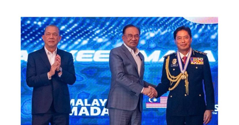 首相安华(中)在反贪会周年庆典上与阿占巴基(右)握手，左为副首相法迪拉。