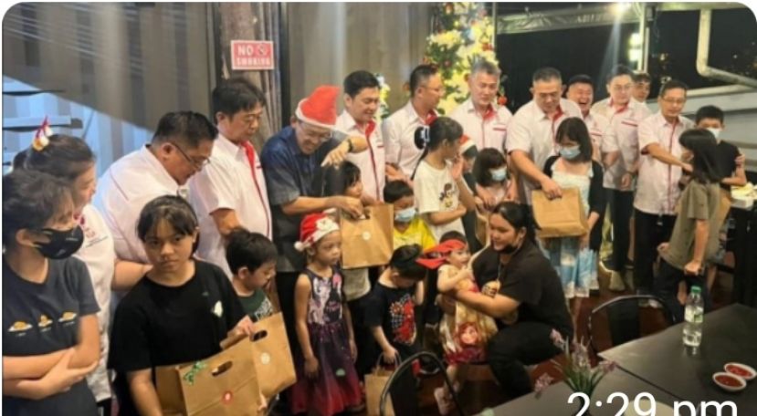 薛华东（左5）连同毕打拿忠福宫理事会成员派发礼物予古晋救世军男女童；左3起为筹委会主席张荣华、该宫理事会主席许义华等人。