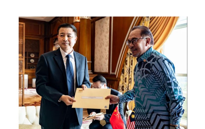 首相安华(右)移交邀请函予王小洪(左)，邀请中国国家主席习近平明年访马。