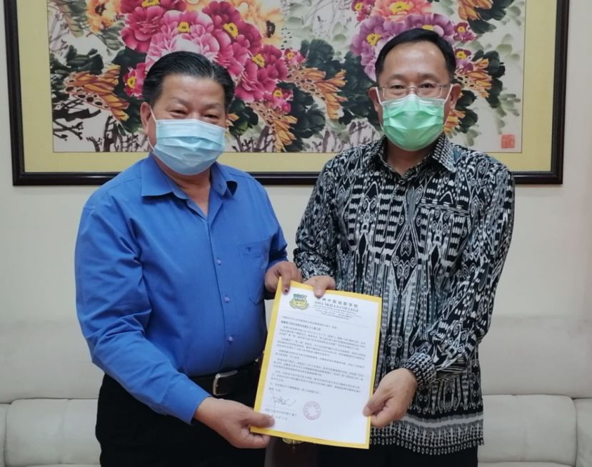 砂医总会长江宗兴（左）移交邀担任上宾函件予中国驻古晋总领事邢伟平。