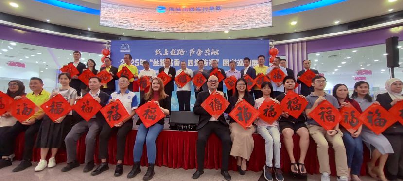 “丝路书香·四海传福”图书巡回展在古晋开幕，各界嘉宾与公众手持写有“福”字的春联合影留念，寓意把书香与祝福带进社区，弘扬中华文化、促进中马民心相通。