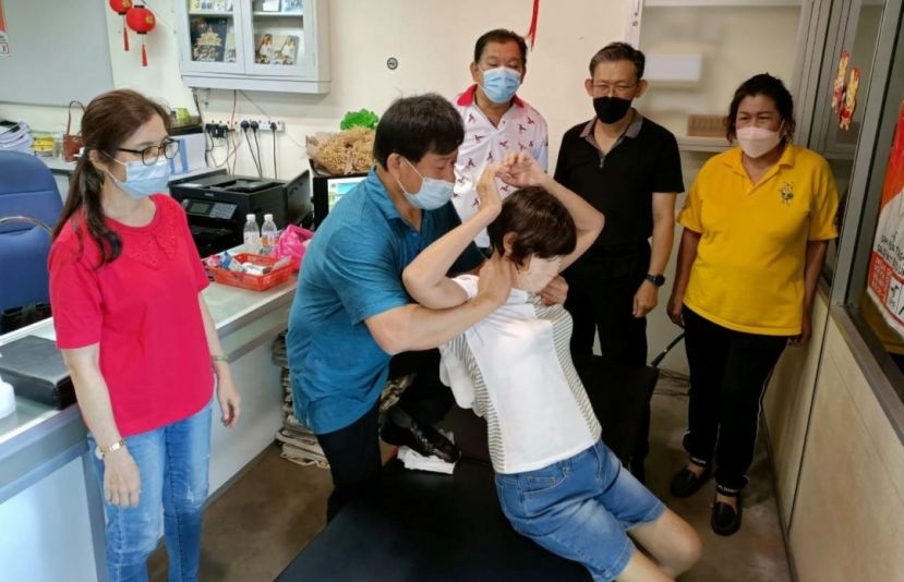 人联党峇都林当支部主席薛华东（右2）与甲必丹何月明（右1）、义诊筹委会联合主席陈中兴（右3）看着来自台湾许国模医师为民众正骨；左是林淑惠医师。