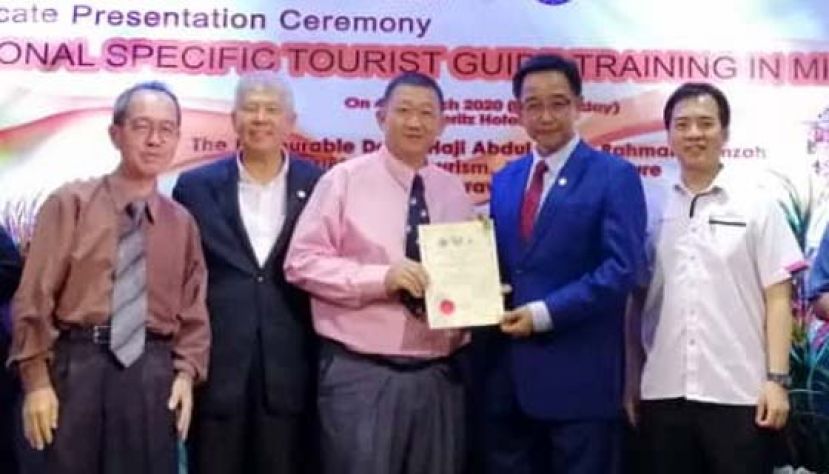拿督阿都卡林颁发特别区域导游结业证书予其中一名学员蔡志维(中)，左2是拿督陈超耀助理部长，右1是许赞麒。