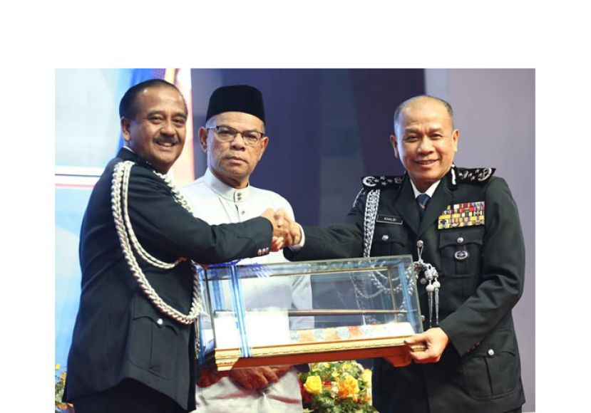 丹斯里拉扎鲁丁(左)在内政部长(中)见证下移交总警长职权予莫哈末卡立(右)。