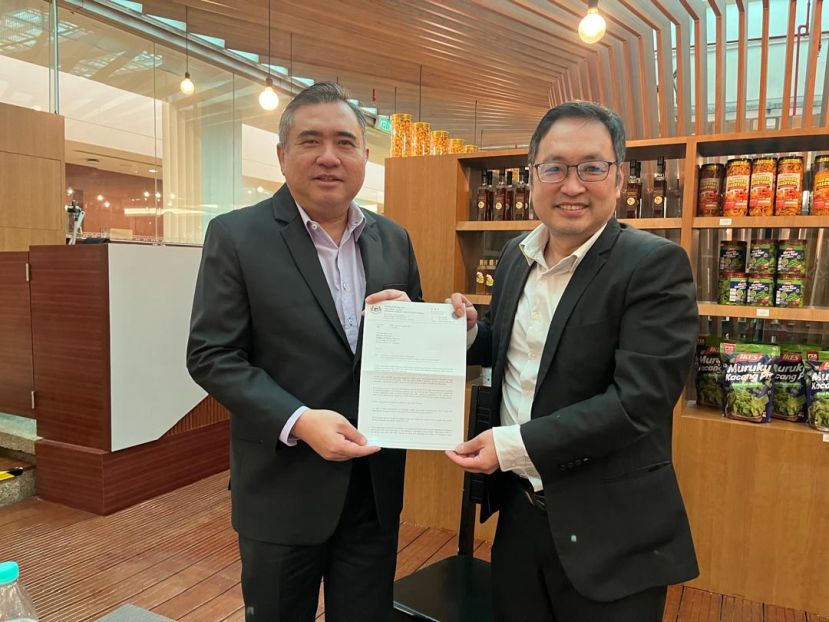 砂行动党主席兼实旦宾区国会议员张健仁（右）代表砂拉越罗里司机和业者提交诉求予交通部长陆兆福（左）。