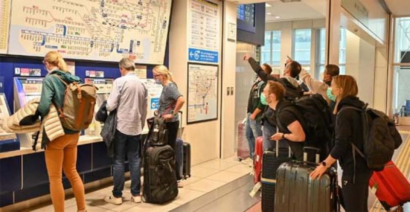  周二扺达东京羽田机场的外国旅客，准备购车票到市中心。