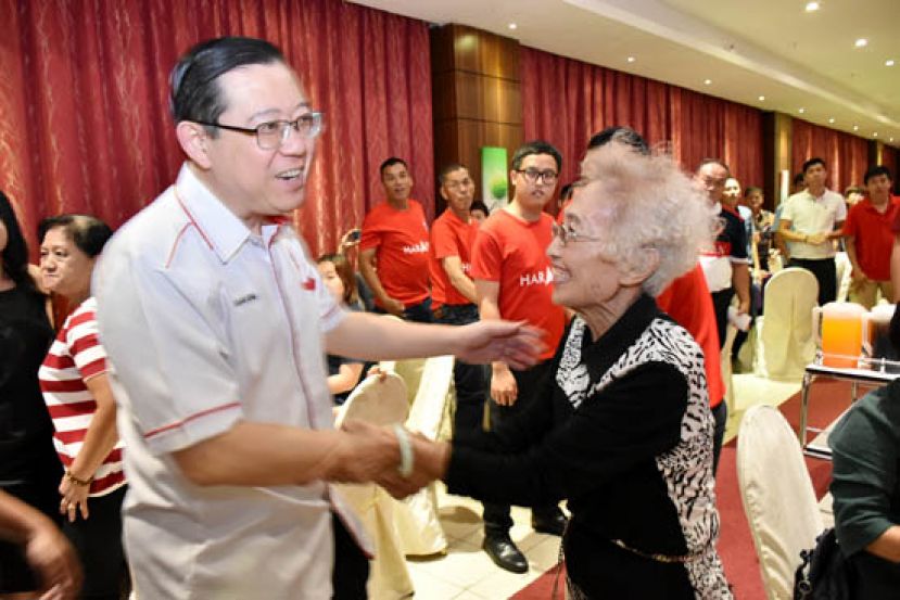 行动党秘书长林冠英（左）与张守江夫人沈瑶瑟（右）握手言欢。