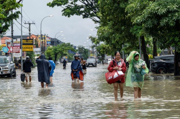 峇里岛暴雨导致市区淹水，许多游客只能徒步涉水。
