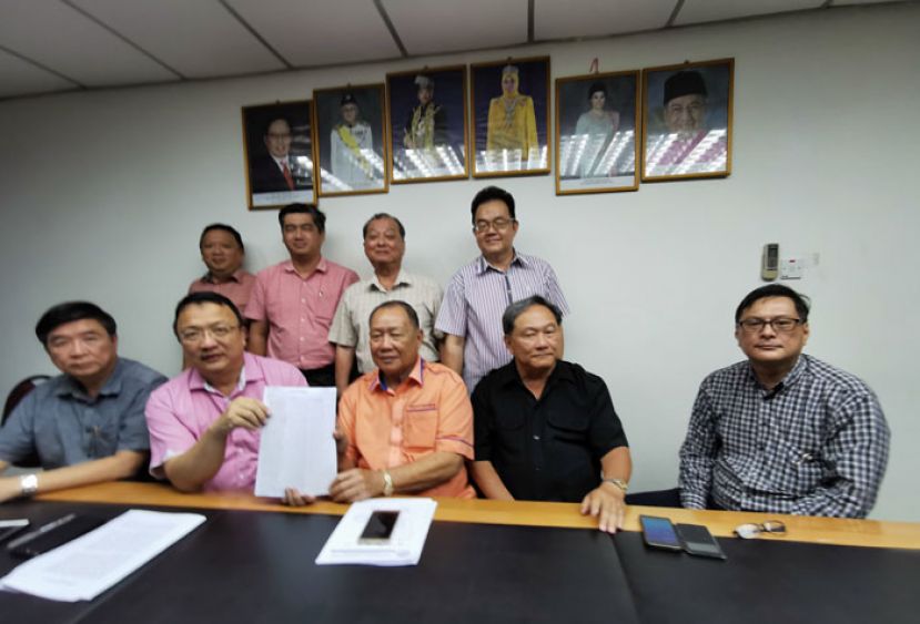 砂津贴华小董事会联合总会秘书长蔡文铎（前排左2）及会长本固鲁邱民伟（前排左3）展示调查问卷数据报告。