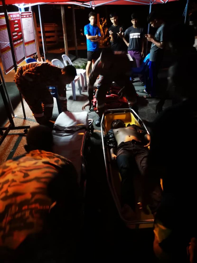 命大的男子被抬回甘榜，准备送往医院。