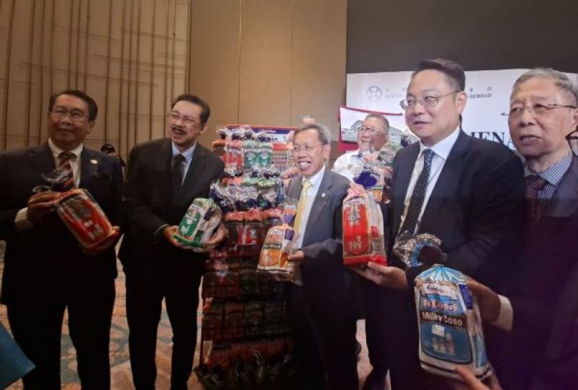 砂拉越副总理拿督阿玛沈桂贤（右四）在谅解备忘录签署仪式上，展示 Gardenia 面包时影。
