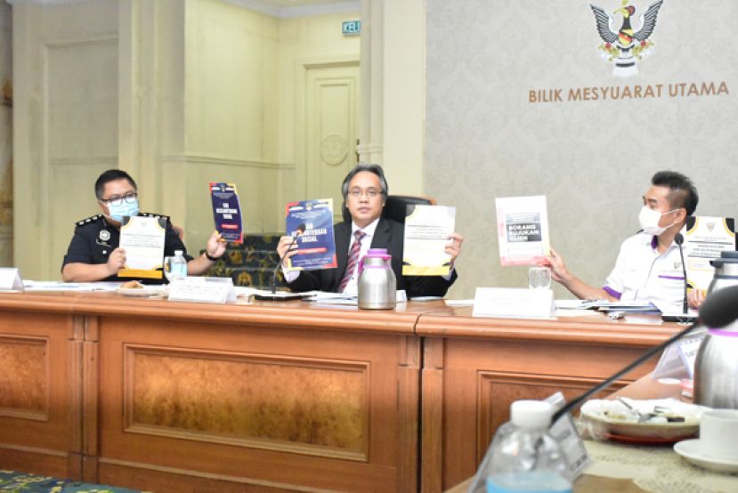 砂社区和谐部副部长莫哈末拉西（中）召开新闻发布会。