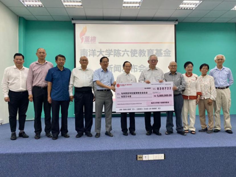 林忠强（右五）代表南大教育与研究基金会移交500万令吉模拟支票给董总，由陈大锦（左六）接领。左起为杨安山、庄俊隆、吴小铭、杨应俊和陈友信；右起为陈培和、王宝玉、魏顺莲和林顺忠。