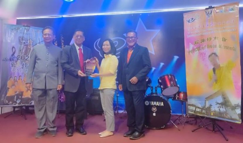 在筹委会主席贝迪龙（右）以及财政陈锦生（左）的陪同下，石角路艺星歌唱娱乐文娱社主席兼大会会长天猛公拿督陈如飞（左二）赠送纪念品予主宾拿督阿玛沈桂贤的代表许德婉时摄。