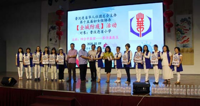 晋汉连省华总妇女组秘书（左6）、妇女组主任张慧娇（右9）和&ldquo;猫城一心，全城防疫&rdquo;讲座筹委会主席朱缮霖（右7）在晋汉连省华总署理会长兼古晋中华小学校董会主席拿督王长福（左9）见证下，分别移交防疫品给晋汉连省华小董联会署理会长田松茂（左7）、晋汉连省华小董联会会长蔡文铎（左8）和古晋中小小学第三校校长朱珍妹（右8）。