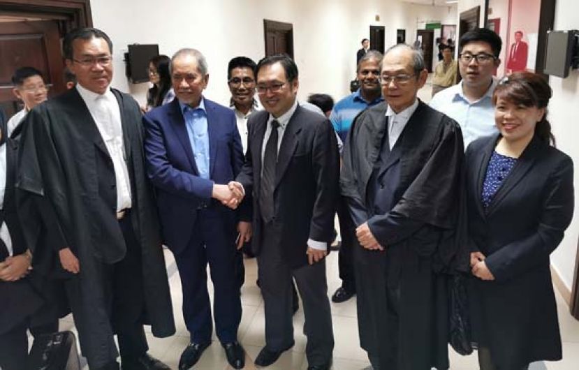 毁谤案和解而撤销，张健仁（右三）和拿督斯里旺朱乃迪（左二）在法庭外握手言和。
