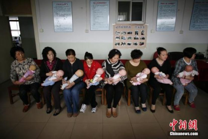 图示：学员在天津一职业培训学校学习给婴儿喂奶。