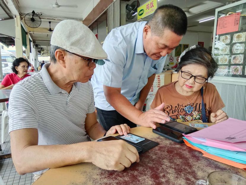 巴都林当区议员施志豪（中）指导和协助长辈申请砂政府福利。