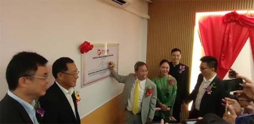 主宾拿督阿玛沈桂贤在牌匾上签名时摄。左二为古晋驻驻古晋总领事邢伟平。