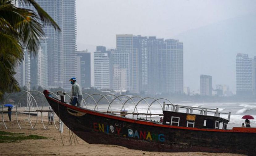 气象局表示，灾情最严重的地区预计将是中部的两个省。图为岘港的渔民在海滩上固定渔船，以防台风袭毁。
