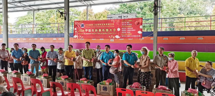 峇楮吉当州议员拿督罗克强（左九）、巴达旺市议会主席陈开（左十一）紫、辉阁阁长蔡岷谷（左十三）、天猛公拿督陈如飞（左七）拿督蔡传伟（左五）、本固鲁林应发（左三）、 甲必丹林应国（右四）、甲必丹黄振荣（右二）、筹委会主席谢嵩（右六）及龚发信（左一）在十哩中公体育馆移交红包及礼盒给受惠者。