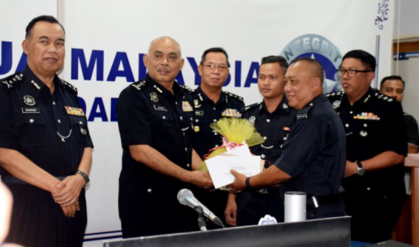 阿兹曼移交警察部队福利金及礼品予建功的威廉贝尔。(左)是砂副警察总监莫哈末杜莱迪，(右)为林明城助理总监。