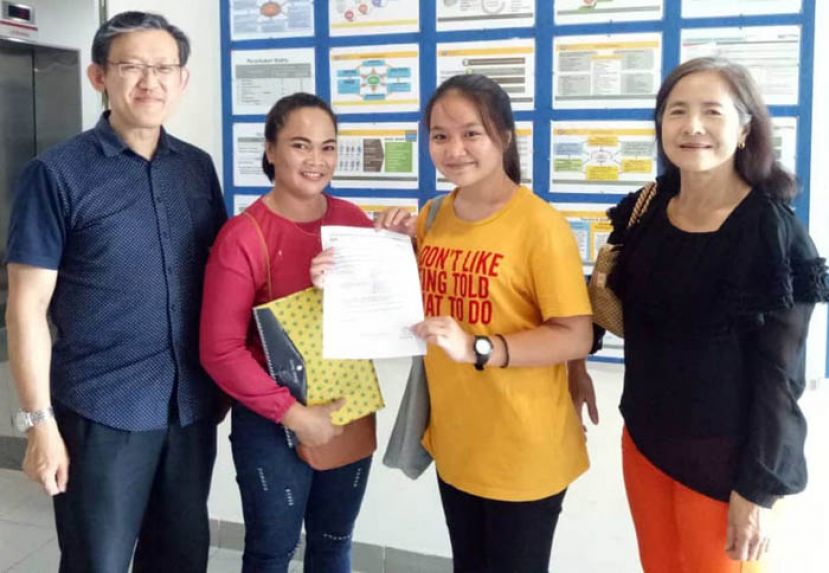 获得公民权的蔡莉华（右2）在母亲哇迪（右3）及姑姑莉莉（右）陪同下，向薛华东感恩出示被录取进入大学先修班函件。