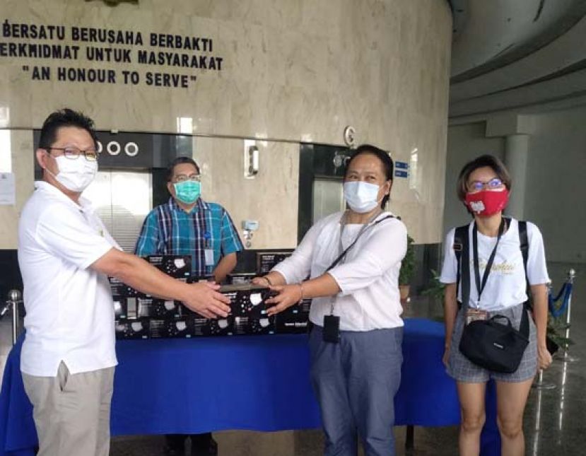 在古晋南市市长拿督黄鸿圣（左二）见证下，古晋活力团队队长郑志国（左）将口罩移交予古晋省新闻从业员协会主席杰克琳（右二）。右为该协会财政庄可丽。