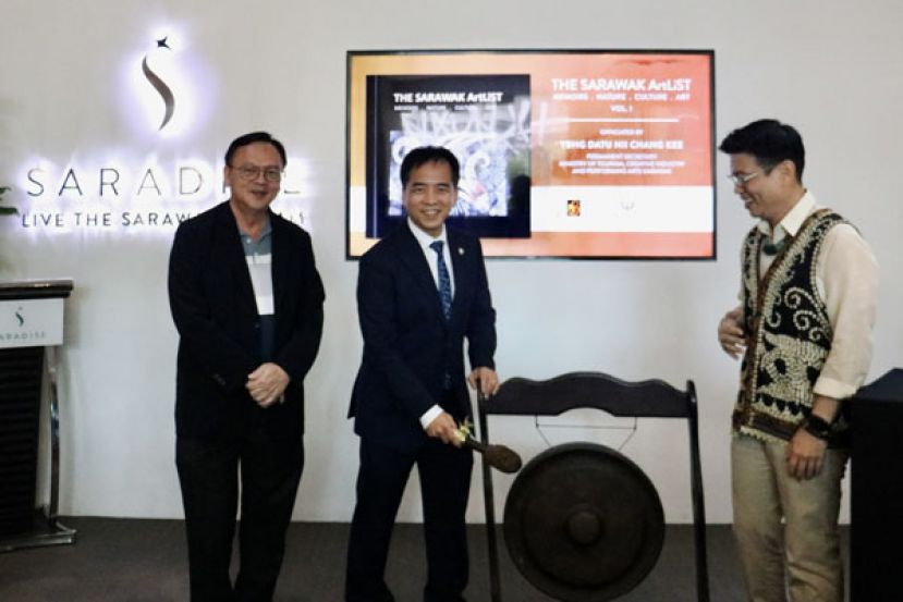 拿督许赞麒（中）为&ldquo;砂拉越画家画册&rdquo;主持推展敲锣。左一为罗克强，右一为&ldquo;砂拉越画家画册&rdquo;作家吴得瑜。