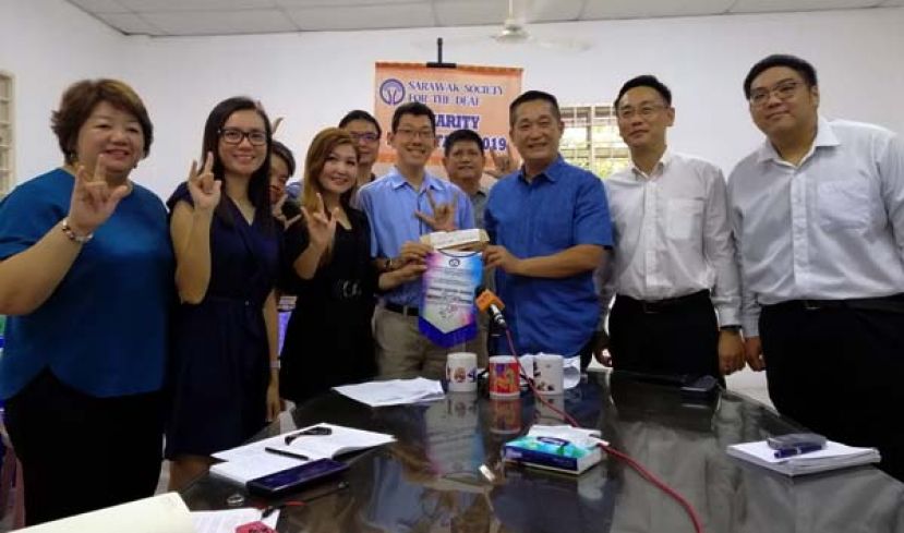 在众嘉宾见证下，砂人民公正党巴都林当区州立法议员施志豪律师（右三）移交三千令吉捐款支票予砂聋哑协会主席郭月萍（左三），右起为砂人民公正党实旦宾区部青年团团长莫惠中律师、砂人民公正党实旦宾区部秘书许明扬律师；(左一)起为砂聋哑协会志工施楚粉及志工王新蕊。