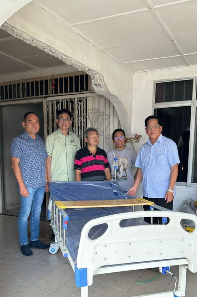 拿督龚财兴(左一)在古晋巴达旺市议会主席陈开(左二)及天猛公拿督陈如飞(右一)的陪同下，把病床交给陈家。