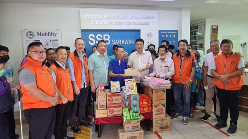 副会长魏铭辰博士（前排右五）移交渡岁红包盲人中心古晋分部主席Ronald Law（左五）。左一起为  青商团理事李伟鸿、理事符致仁、福利组副主任黄国维、秘书长拿督蔡文铎律师。右一起商业组主任苏琮杰  、工业组主任陈育盛博士、人力资源发展组副主任黄长财、盲人中心负责人蔡新锐。
